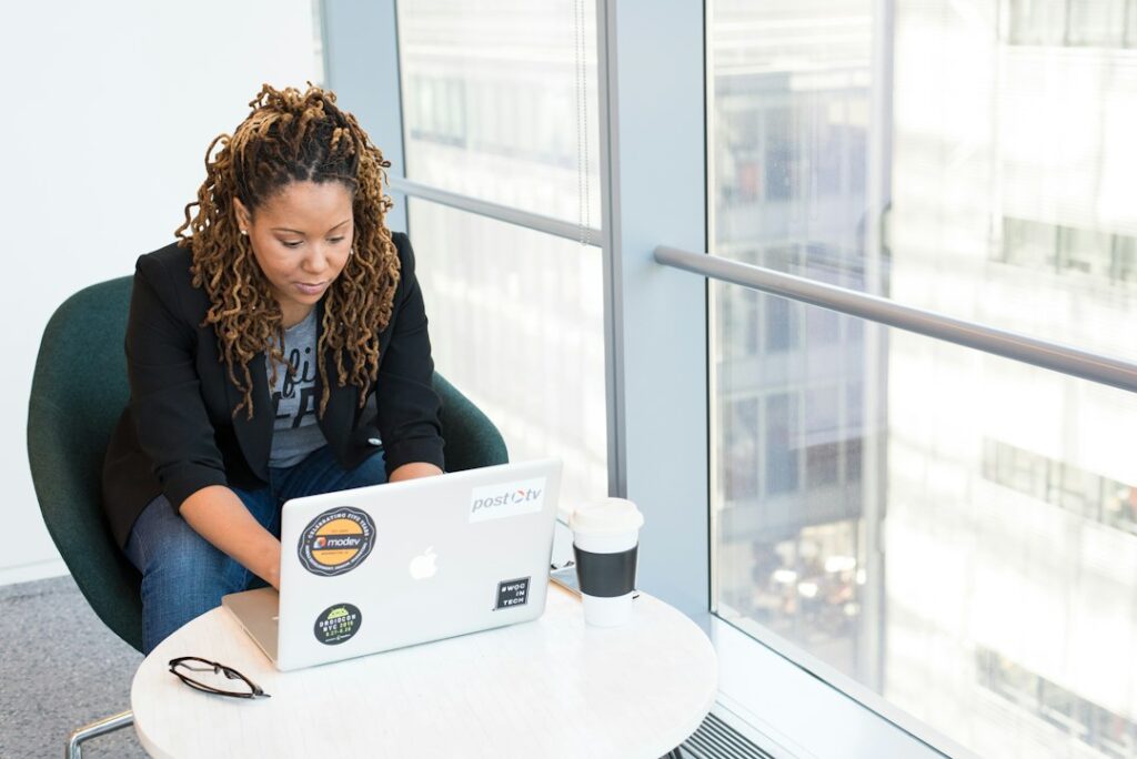 A digital creative reviewing a website on a laptop in a bright, modern workspace